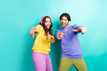 Photo of young couple happy positive smile point fingers you choose headphones isolated over teal...