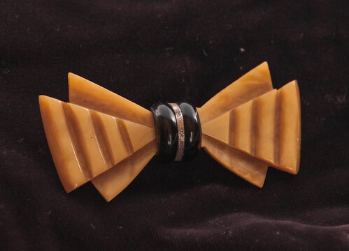 Vintage bakerlite bow shaped brooch on black background