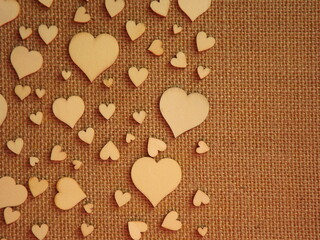 wooden hearts of different sizes on jute fabric as a Valentine's day greeting card. High quality photo