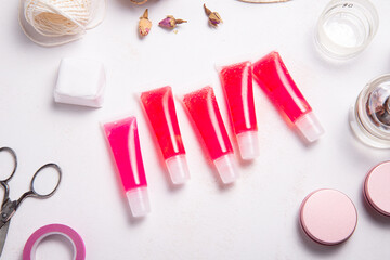 Fototapeta na wymiar Set of homemade lip gloss on wooden desk