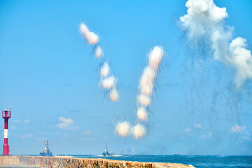 White carbon fiber clouds in blue sky hiding naval destroyers from anti-ship missiles, military show