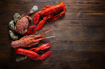 Boiled red Lobsters, crab and crawfish on wooden background. Seafood with copy space
