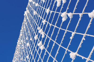 Volleyball net covered with snow. Nature's minimalism. 