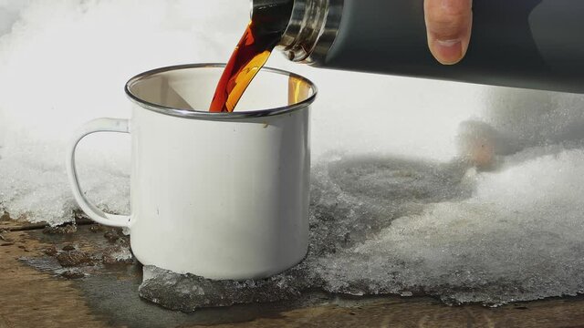 Pouring Coffee From Thermos In Winter yo metal cup