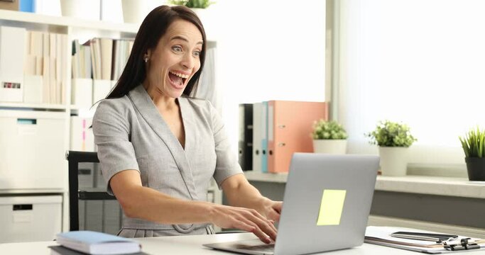 Business woman typing on laptop keyboard and enjoying positive news 4k movie
