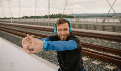 a smiling athlete in the afternoon training for exercise and listening to music