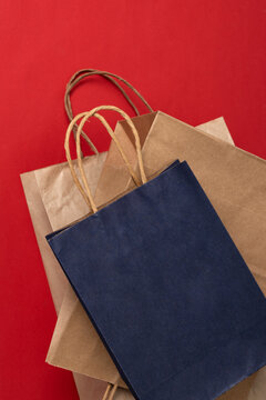 Vertical image of stack of paper bags on the red surface.Empty space