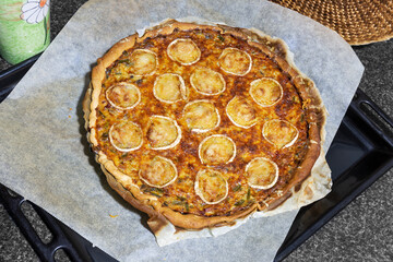Vegetable quiche with bacon decorated with goat cheese
