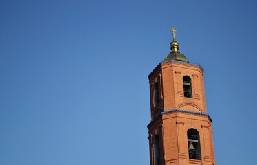 Fototapeta na wymiar Church tower. Blue sky. Background. Cross. Dome