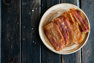 Dried chicken, dried poultry, cut into strips on a plate on a wooden background. High quality photo