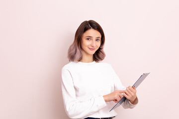 Portrait of a young girl model beautiful and natural with a tablet in her hands in the studio