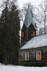 Fototapeta na wymiar An old wooden country side christian church during winter in the evening with lights glowing inside