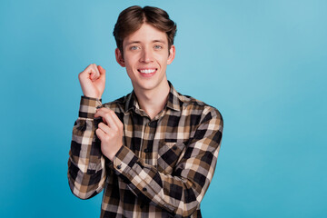 Portrait of young man fix correct his button prepare for date day wear shirt isolated over blue...