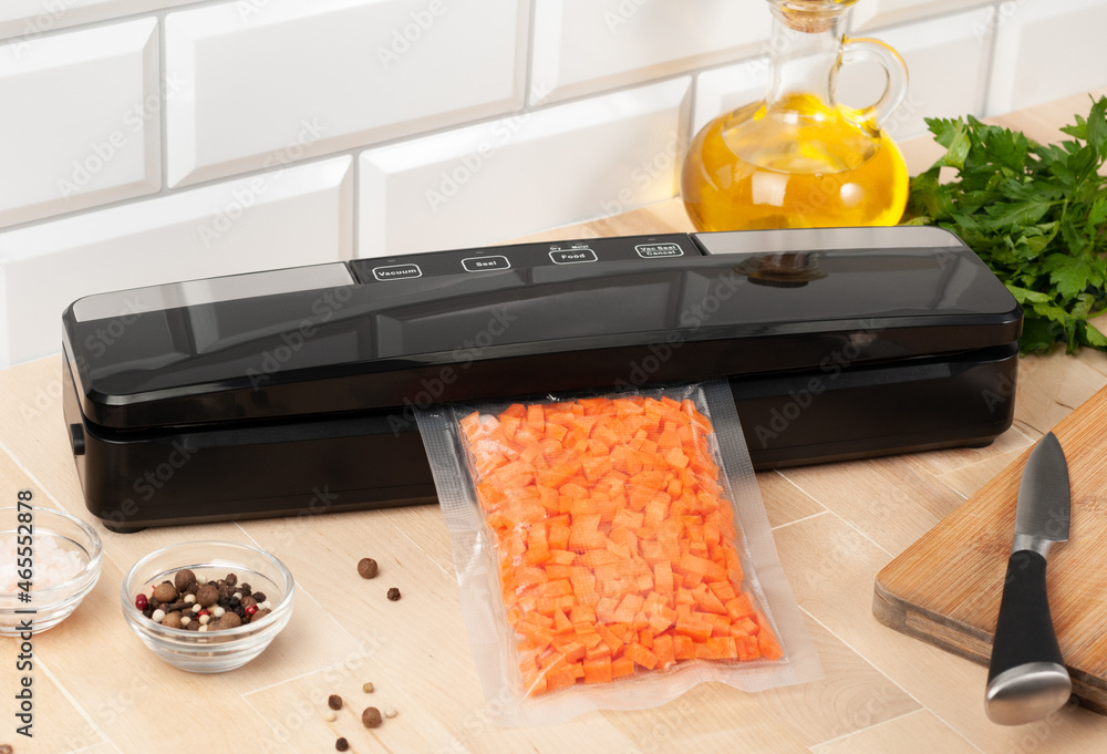 Wall mural vacuum packing machine. for long-term storage of food. packs chopped carrots. top view light backgro