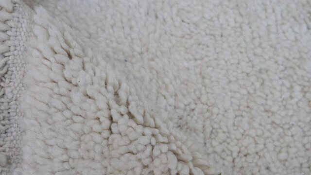 Authentic traditional handmade Moroccan Berber carpet in Beni Ourain style. Morocco home decor, texture background footage.