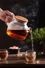 Foto op Plexiglas Black hot tea with sugar lollipops on a wooden table © Татьяна Медведцкая