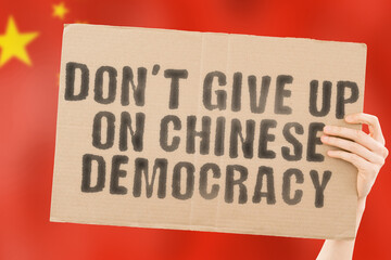 The phrase " Don’t Give Up on Chinese Democracy " on a banner in men's hand. Resistance. Demonstration. Fight. Opposition. Demonstrate. Rejection. Fight. Law. Legislation