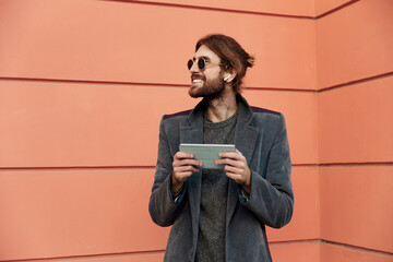 Man using smartphone near orange wall outdoors