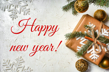 The inscription happy new year with shiny Christmas toy balls on a white background