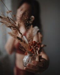 beautiful woman in red underwear with dry flowers