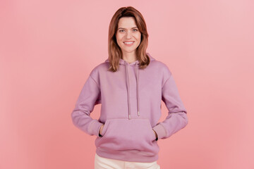 Photo of young cheerful woman happy positive smile wear pullover sporty hands in pocket isolated...