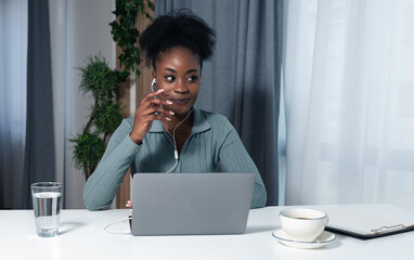 Young happy African American businesswoman dating online via video call over laptop in the office....