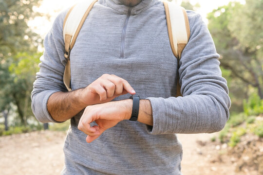 Anonymous guy checking time on smartwatches in woods
