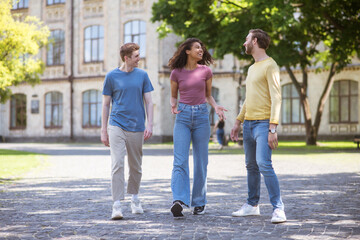 Fototapeta premium Three people walking in the park and discussing something