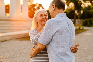 White senior couple hugging and smiling together outdoors