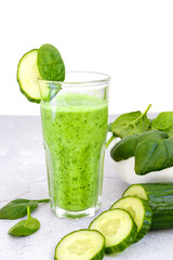 Top view of glasses filled with green spinach and cucumber smoothie on table