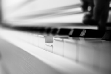 Fototapeta na wymiar Piano keys and one pressed. Black and white photo. Abstract photo.