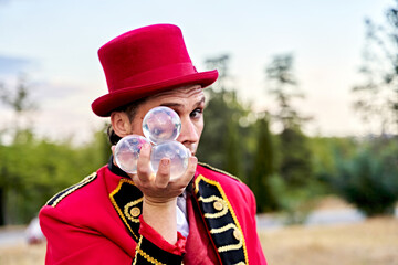 Bearded man in red hat showing bunch of transparent glass balls and looking at camera