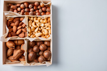 Assorted nuts in box nuts: pecan, almond, macadamia, brazil, cashew, hazelnut, Rich in minerals and protein. Healthy nutrition, high in zinc, magnesium and vitamins, online ordering, shoping concept.
