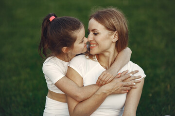 Mother with daughter sitting on a grass