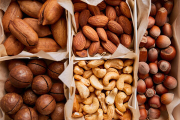 Assorted nuts in box nuts: pecan, almond, macadamia, brazil, cashew, hazelnut, Rich in minerals and protein. Healthy nutrition, high in zinc, magnesium and vitamins, online ordering, shoping concept.