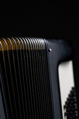 Bellows and bass buttons of an accordion on a dark background