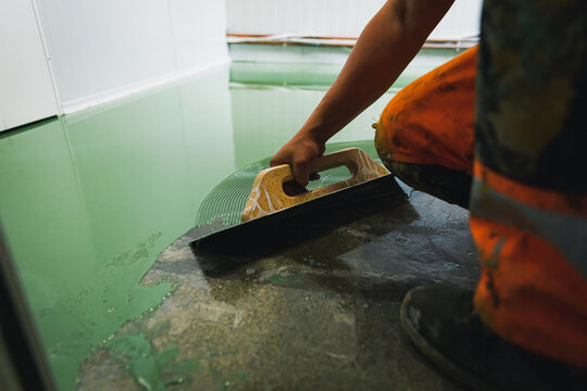 Skilled worker applies green epoxy paint