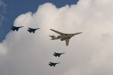 A group of SU-35S fighters and a Tu-160 supersonic long-range strategic bomber fly over Moscow's...