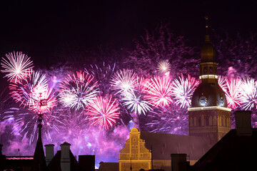 Riga cathedral from the 13th century with fireworks in the background at night. Latvia.
