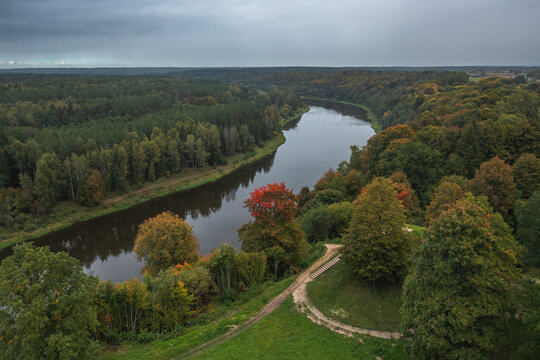 Punia mound in Lithuania with green grass and autumn trees background, road to mountain