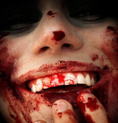 A girl in the image of a zombie smiles and looks at the camera.
A crazy girl with a bloody...