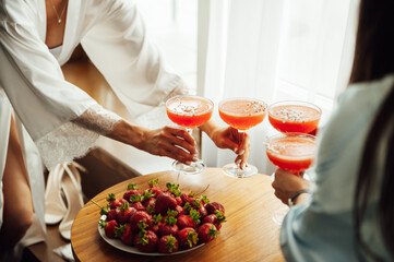 Sexy girls in silk robes are having fun and drinking cocktails. Aperol spritz