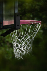 Close-up of a sun faded outdoor basketball hoop and an aging net