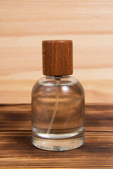 Perfume bottle on dark wooden background woody scent with copy space for text
