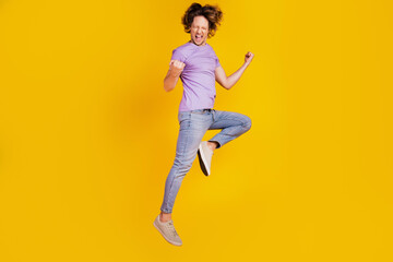 Fototapeta na wymiar Photo of positive winner champion man jump celebrate victory wear casual jeans clothes on yellow background