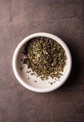 selective focus, natural green leaf tea. brewing in a clay bowl. vertical angle, macro. on a dark background. for menus and cafes