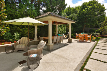 Backyard garden gazebo, table and chairs, umbrella, and stone path