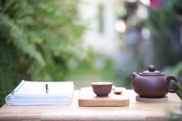 Teapot and tea cup with old book and diary