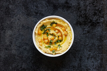 Hummus - chickpea traditional jewish and lebanese cuisine meal on black background, flat lay, from above overhead top view, closeup, houmous is a vegan healthy legume food - obrazy, fototapety, plakaty