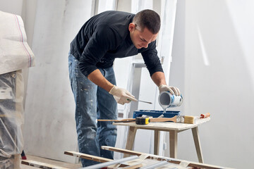 Young adult man painting on a DIY budget renovation of his new home apartment.